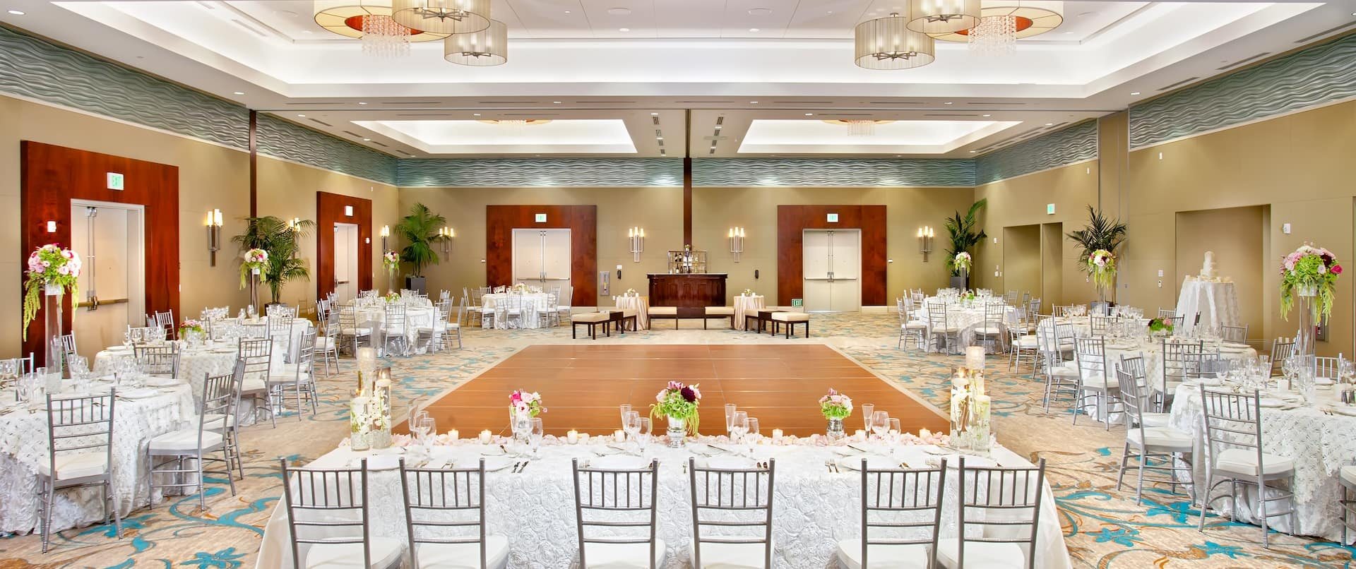 The Shearwater Ballroom at Cape Rey Carlsbad Beach set for a wedding reception with round tables and a dance floor