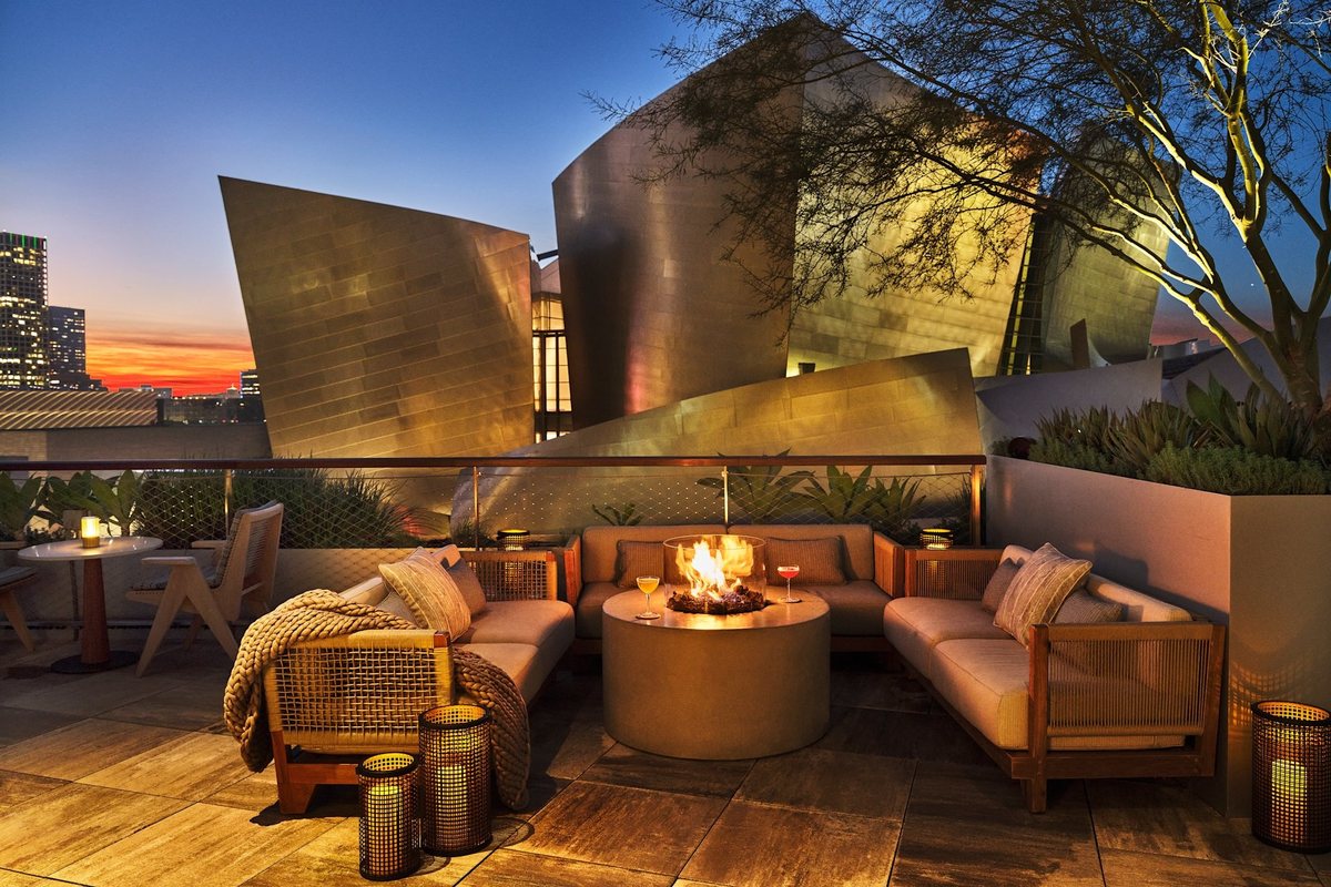 An outdoor lounge with a fire pit beside the Walt Disney Concert Hall at Conrad Los Angeles