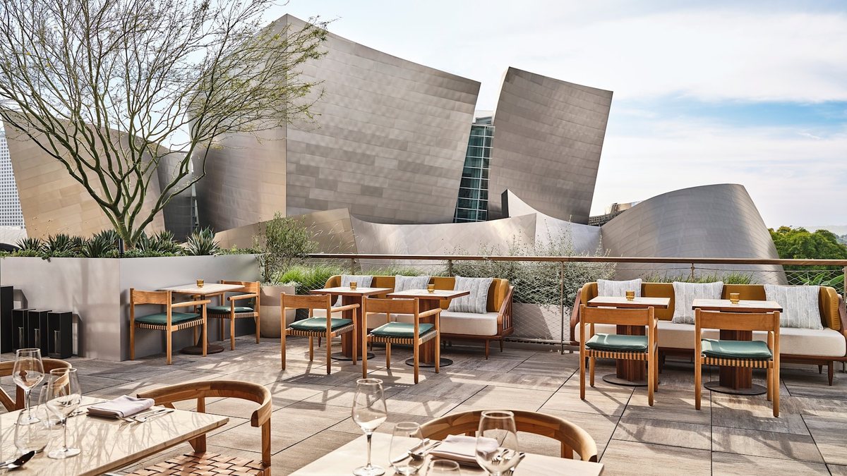 The San Laurel terrace at Conrad Los Angeles with dining tables facing the Walt Disney Concert Hall