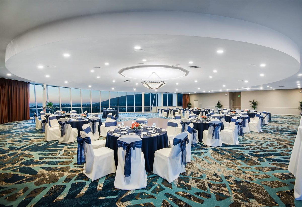 Top of the Harbor at Crowne Plaza Ventura Beach set with round tables beside panoramic windows