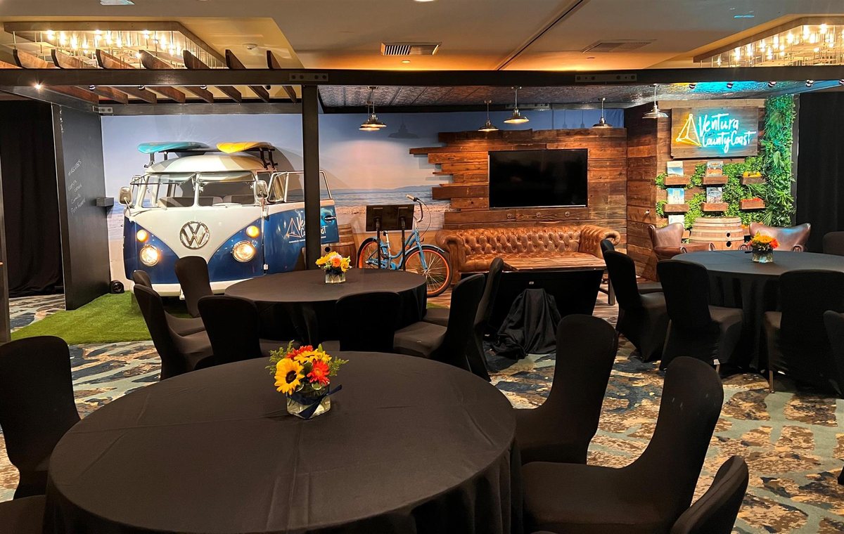 The San Miguel ballroom at Crowne Plaza Ventura Beach with round tables and a vintage van display