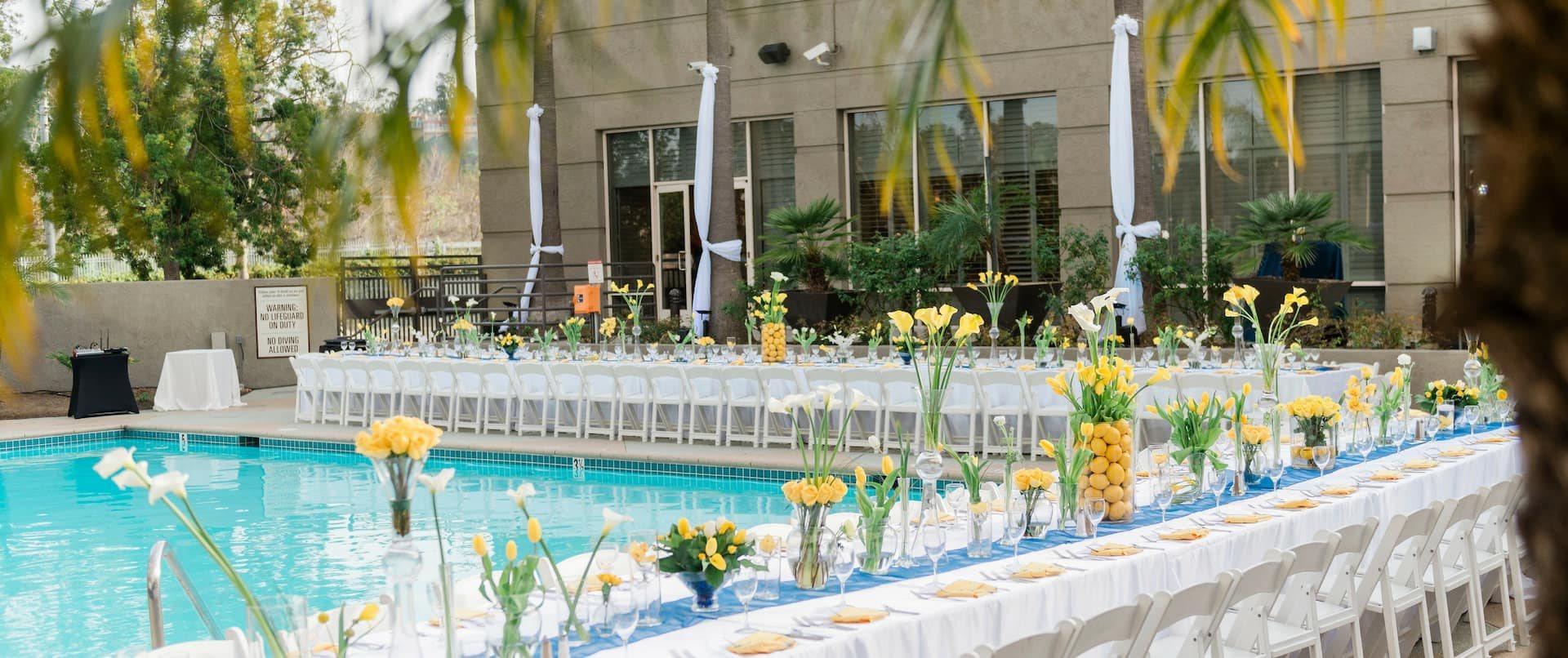 A poolside reception at DoubleTree San Diego Mission Valley with flowers along the pool