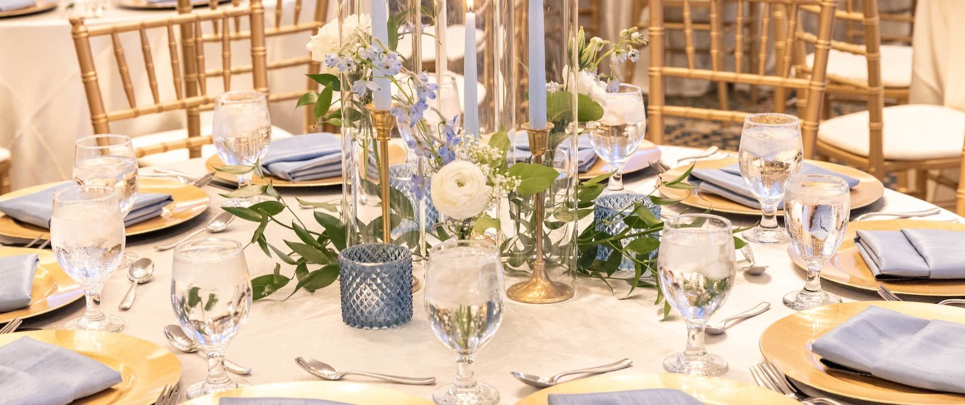 A dinner table set with glassware and white flowers in a meeting room at DoubleTree Torrance