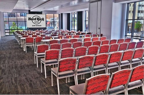 Imagine at Hard Rock Hotel San Diego set theater style with red chairs facing a Hard Rock screen