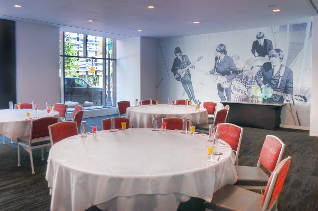Revolution at Hard Rock Hotel San Diego set with round tables in front of a music mural