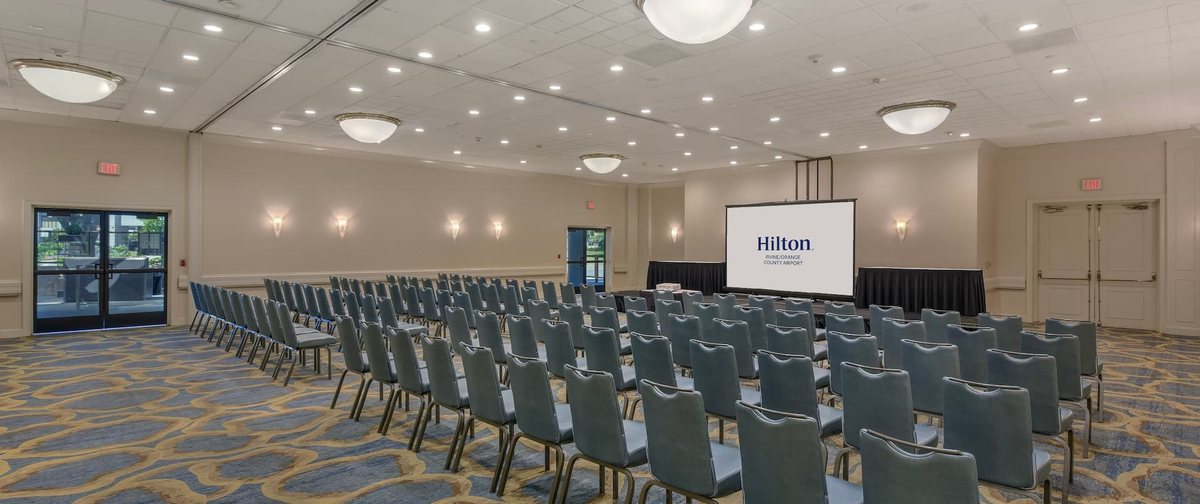 The Monarch Ballroom at Hilton Irvine/Orange County Airport with chairs and a projection screen