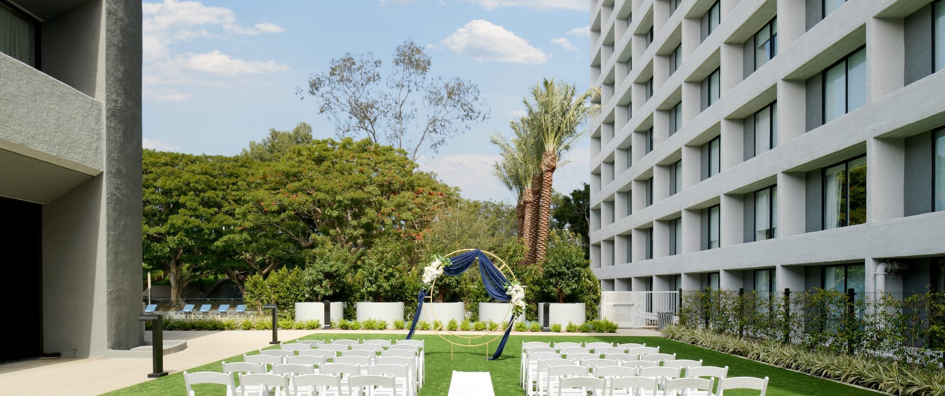 An aerial view of a lawn with a wedding ceremony setup at Hilton Los Angeles Culver City
