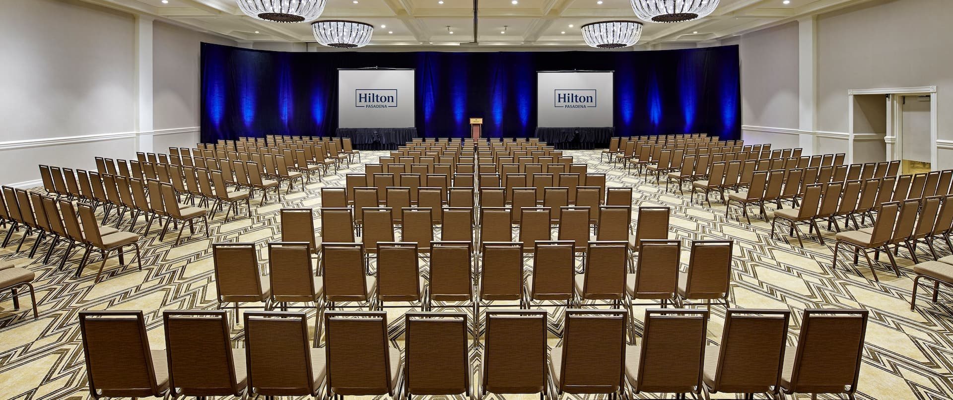 The International Ballroom at Hilton Pasadena set theater style facing a stage and two screens