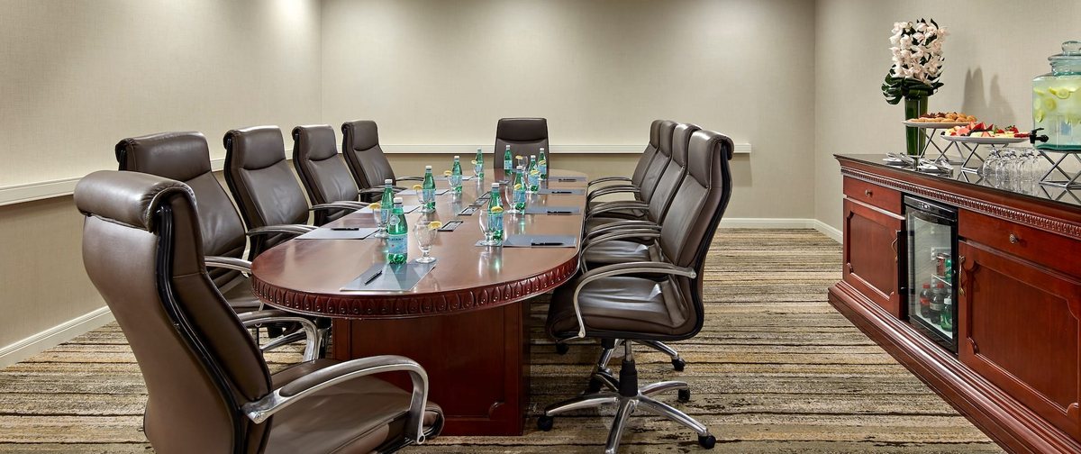 The Santa Monica boardroom at Hilton Pasadena with a wood conference table and leather chairs