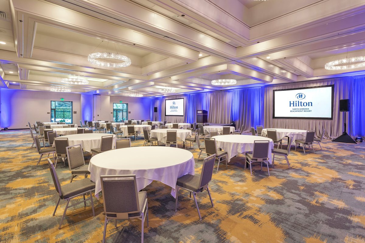 The Santa Barbara Ballroom at Hilton Santa Barbara Beachfront Resort set with round tables facing two screens