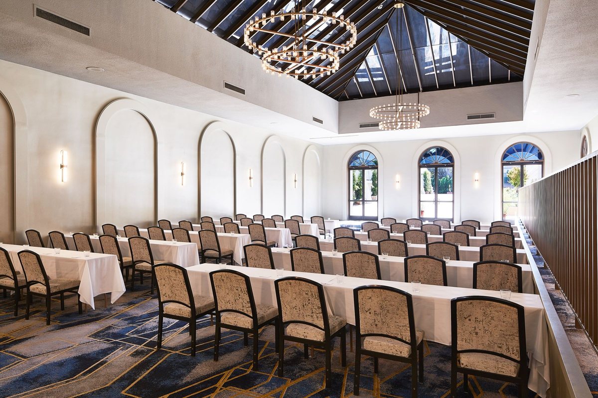 The Piazza Ballroom at Hotel Dena set schoolroom style under arched windows