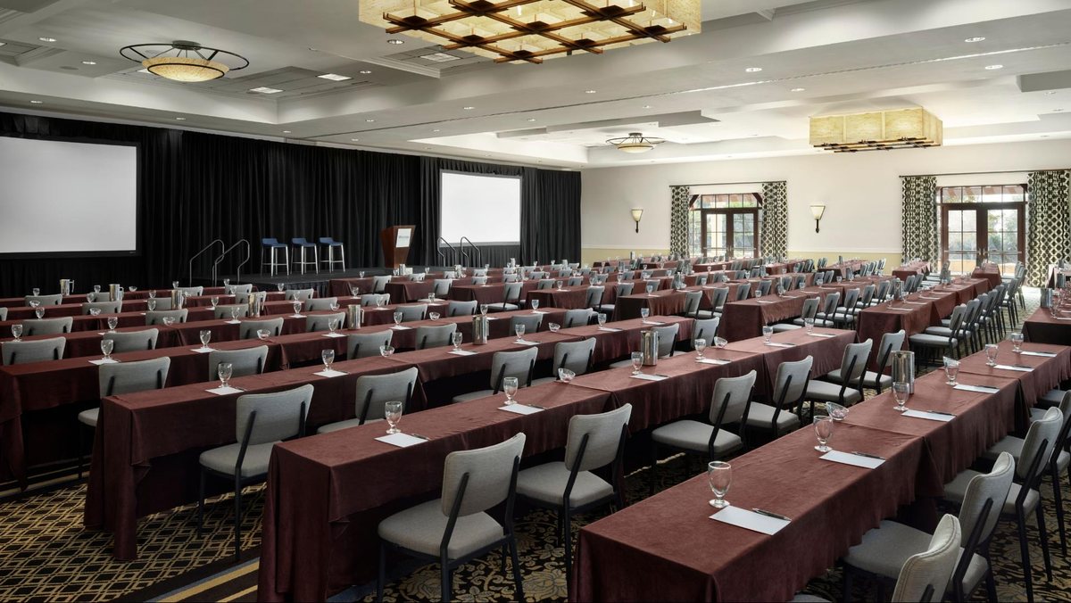The Grand Pacific Ballroom at Hotel Solea set classroom-style facing a stage and screens