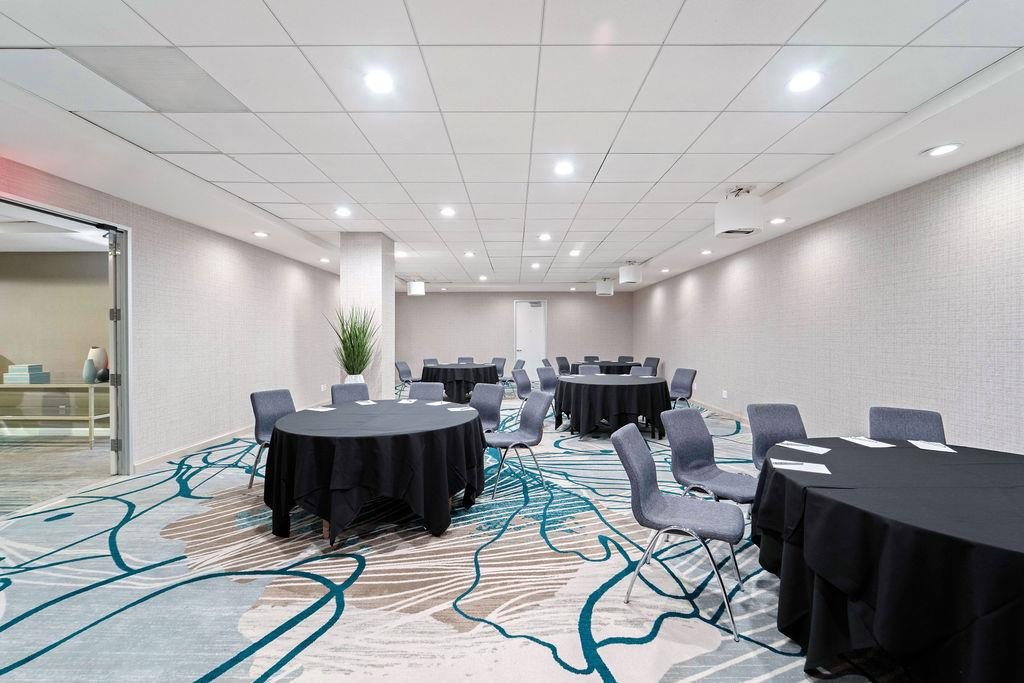 Espada at Hyatt Centric Delfina Santa Monica set with round tables and a wall display