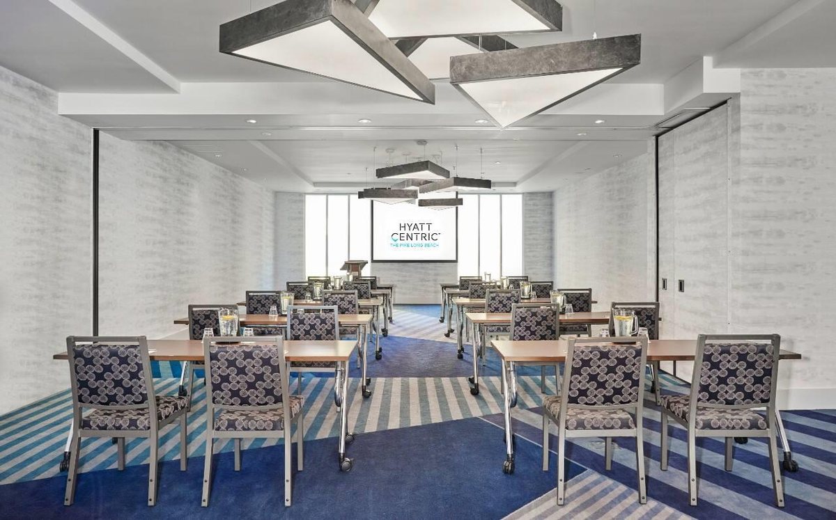 Ballast AB at Hyatt Centric The Pike Long Beach set with round tables under sculpted ceiling panels