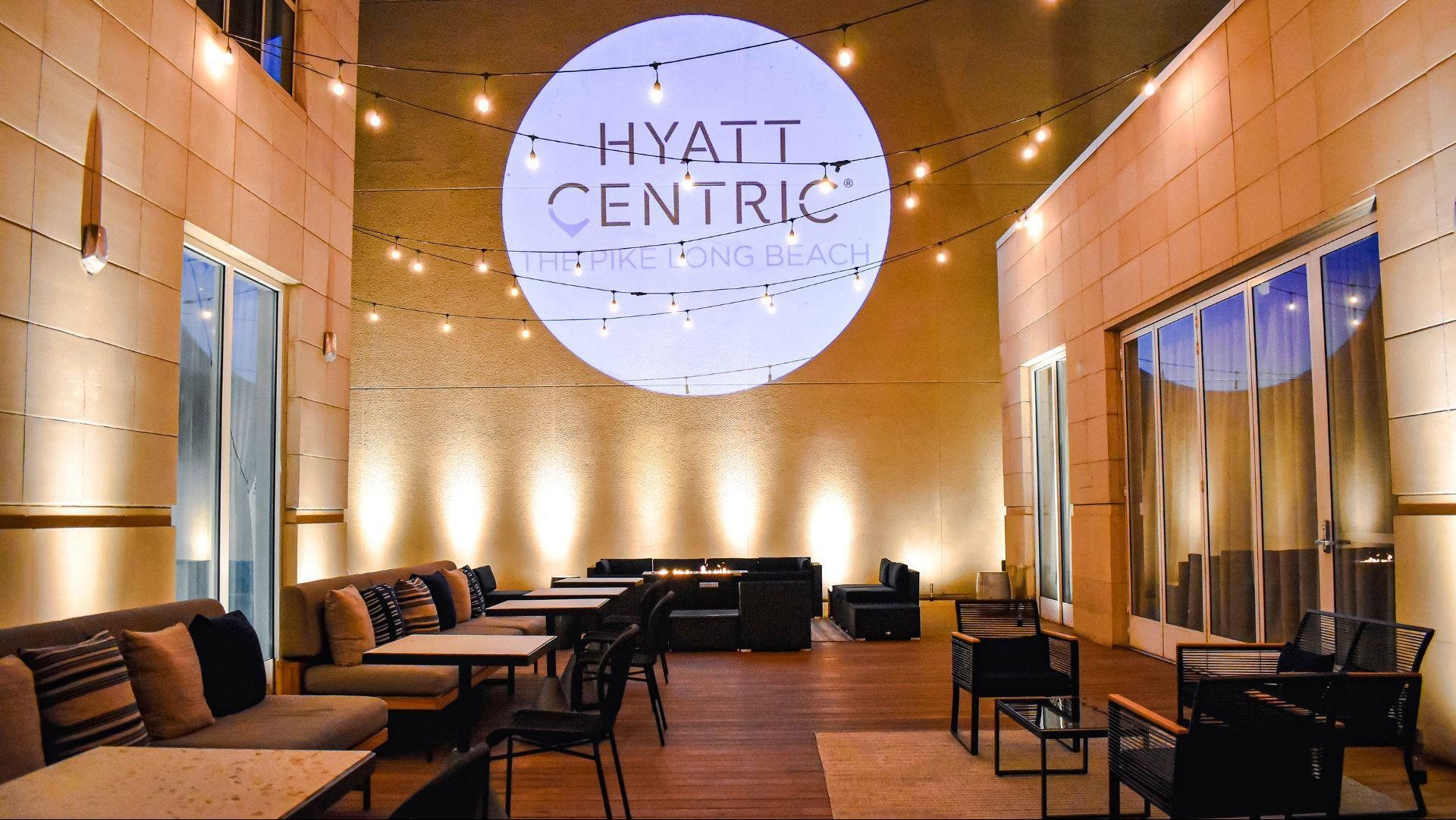 The courtyard at Hyatt Centric The Pike Long Beach at night with a projected Hyatt Centric logo