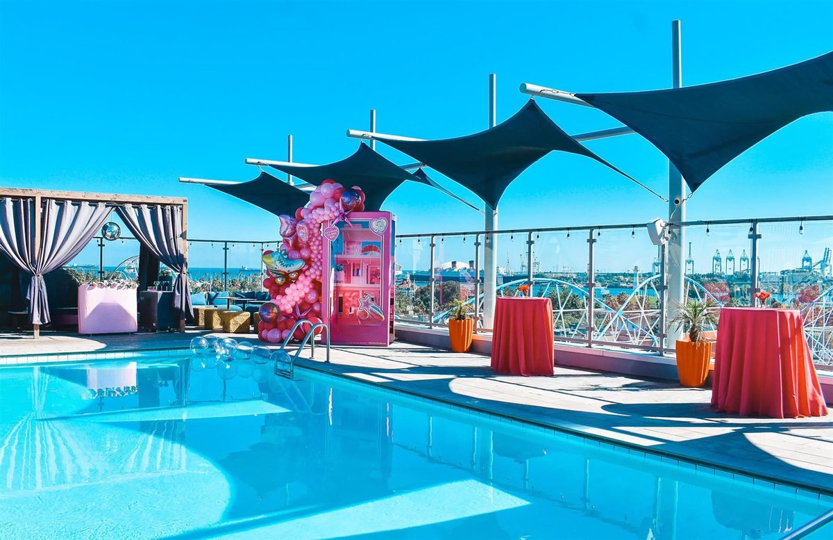 The Topsail Rooftop pool deck at Hyatt Centric The Pike Long Beach with shade sails and cocktail tables