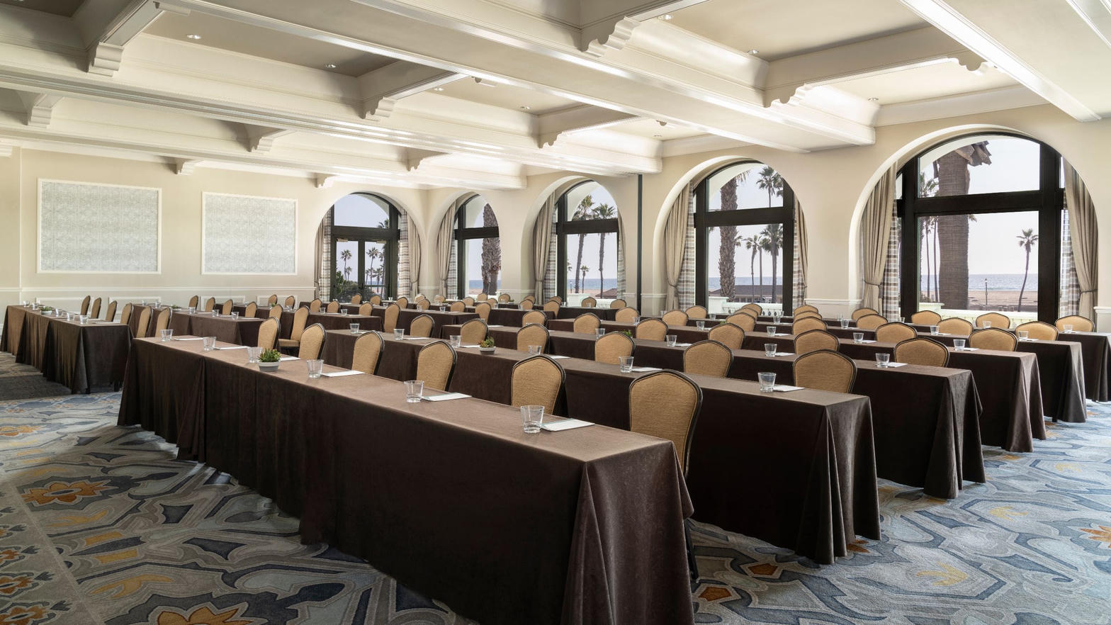 Vista Ballroom classroom setup with white beamed ceiling and ocean-view arches
