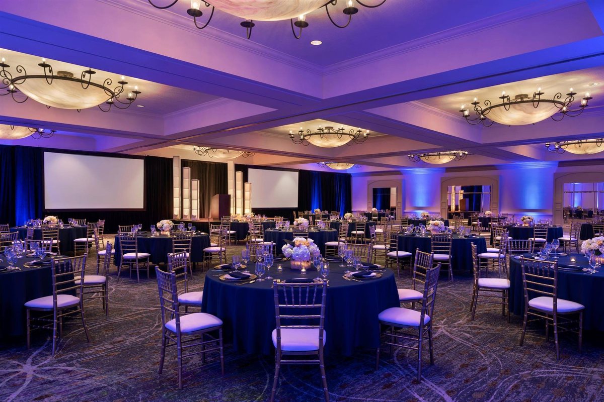 The Grand Plaza Ballroom at Hyatt Regency Westlake set with round tables under blue lighting
