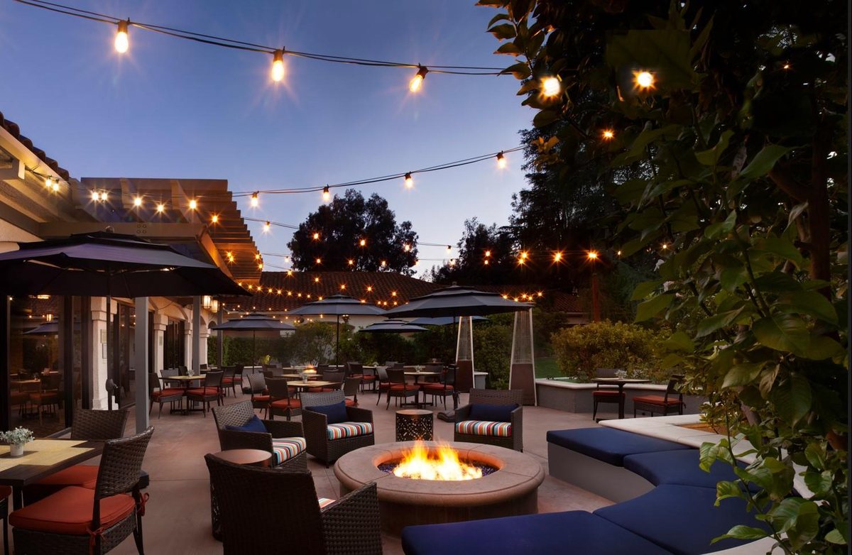 The Harvest Patio at Hyatt Regency Westlake at dusk with fire pits and string lights