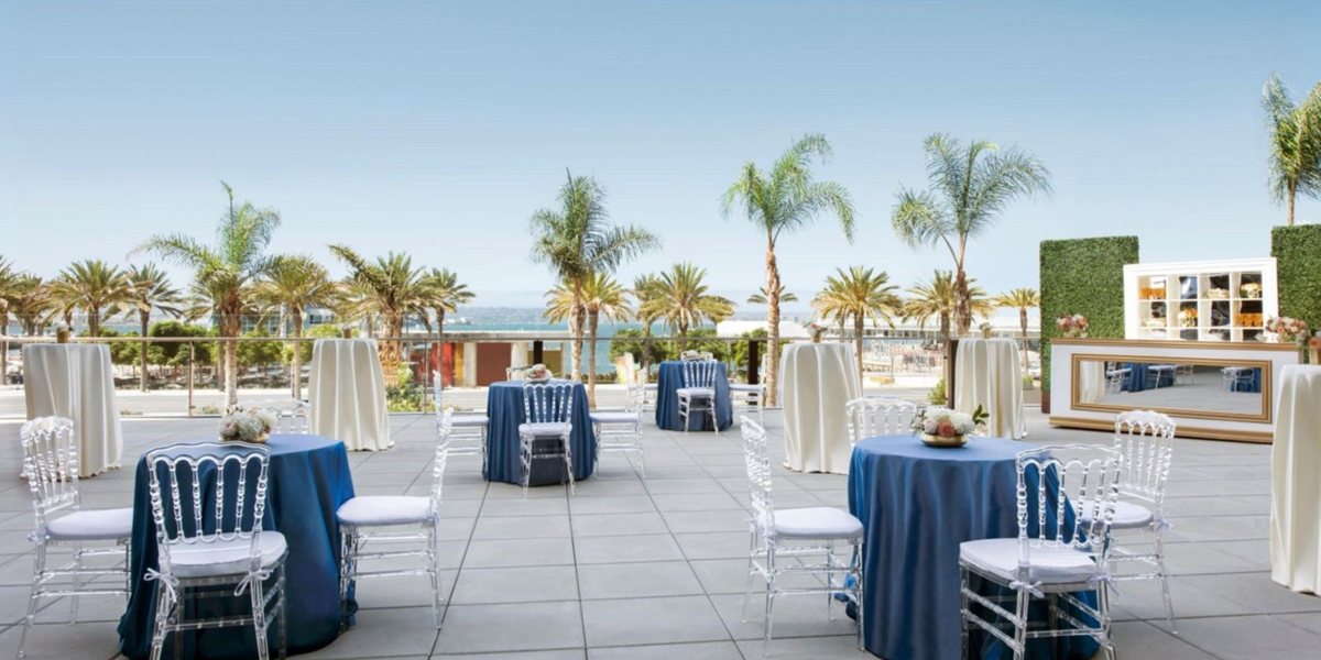 The Bayview Terrace at InterContinental San Diego set with cocktail tables among palm trees