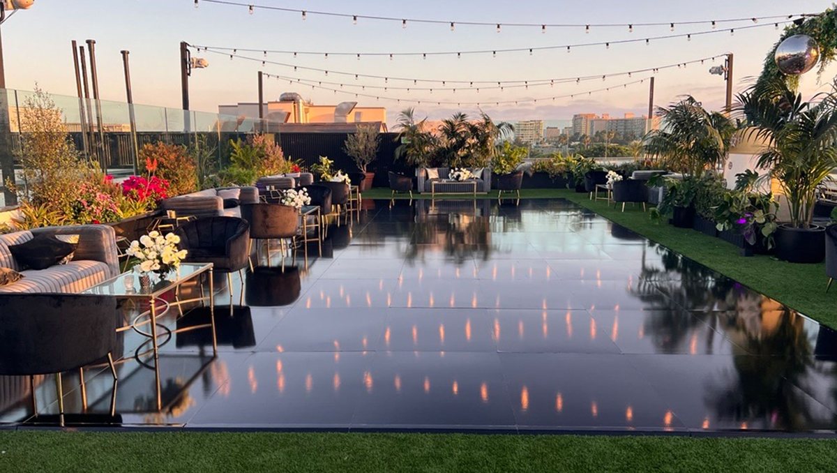 The La Peer rooftop set up for a wedding with string lights and a dance floor