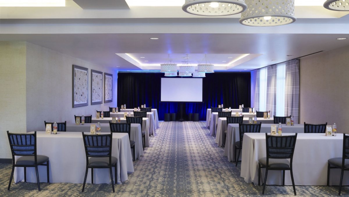 The Bungalow room at Kimpton Shorebreak set classroom style facing a projection screen