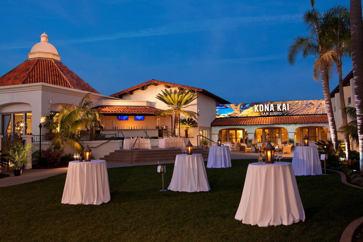 The Cabo Courtyard and Garden at Kona Kai San Diego Resort at dusk with cocktail tables