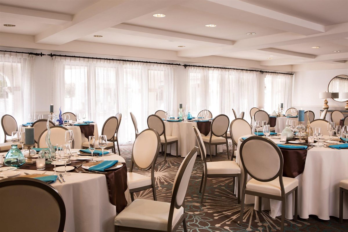 The Coronado Room at Kona Kai San Diego Resort set with round tables and white chairs
