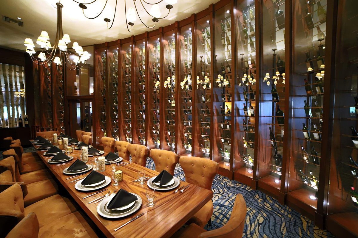 Magnum at Lake Arrowhead Resort and Spa set with a long dining table beside a wine wall