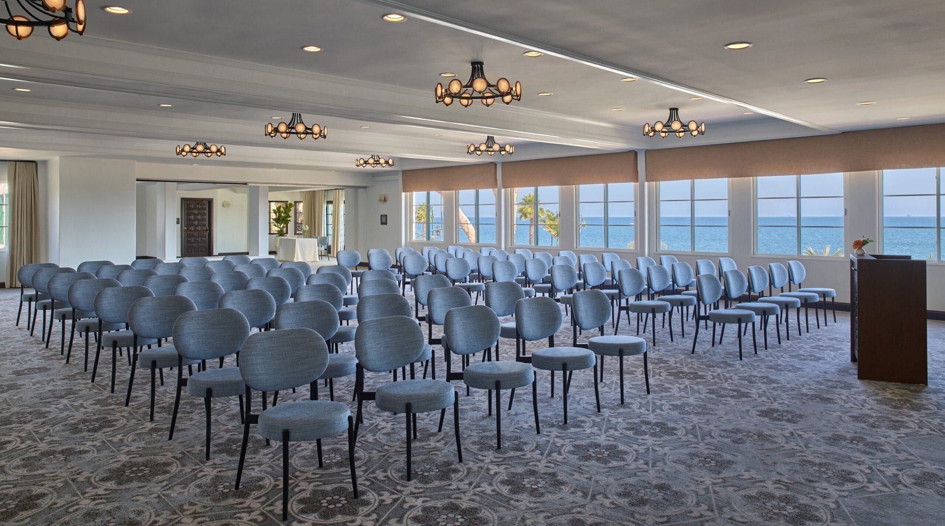 The Pacific Ballroom at Mar Monte Hotel set theater style with a lectern and ocean-view windows