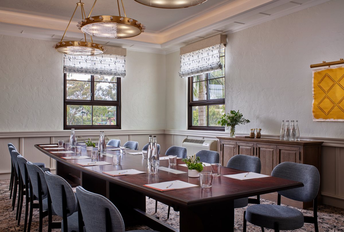 The Studio at Mar Monte Hotel with a boardroom table, chandelier and mountain-view windows