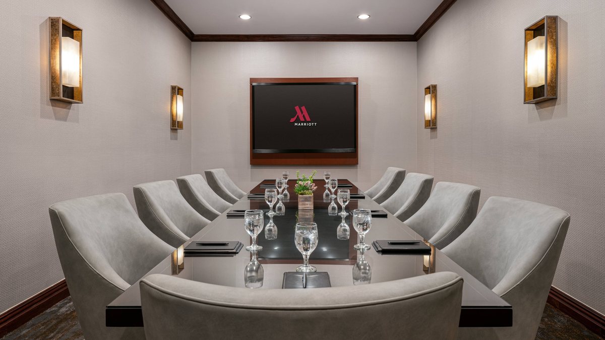 The Executive Boardroom at Marriott Riverside with a conference table, leather chairs and a wall display