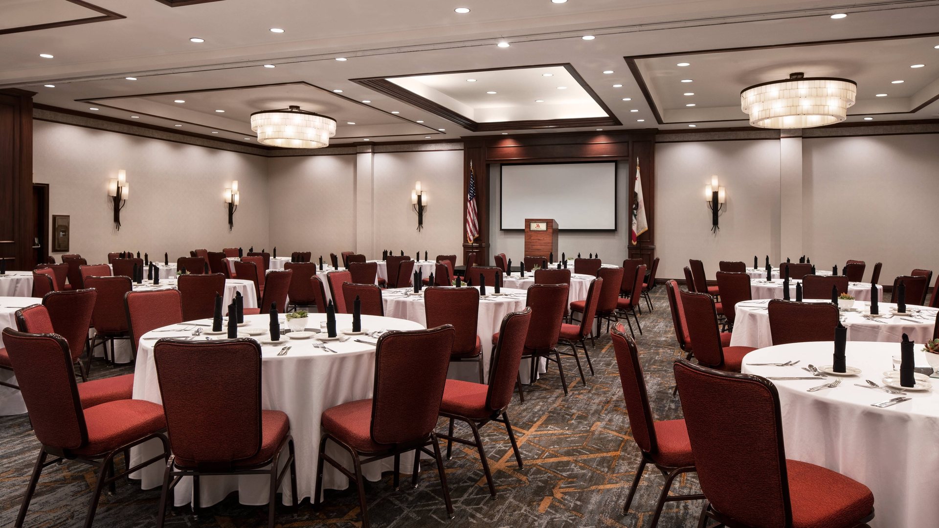 The Grand Ballroom at Marriott Riverside set for a social event with round tables and red chairs