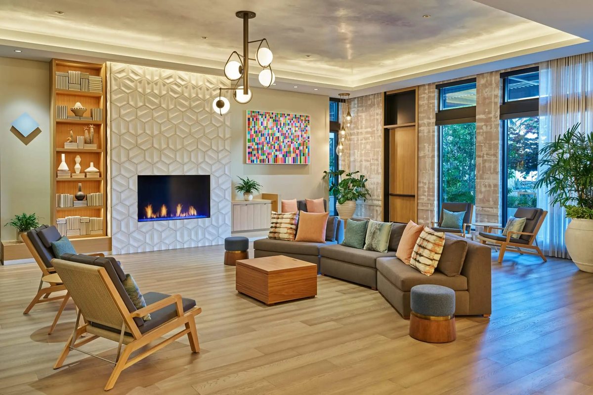 The Shallows library at Mission Pacific Beach Resort with a fireplace, sofas and wood shelving