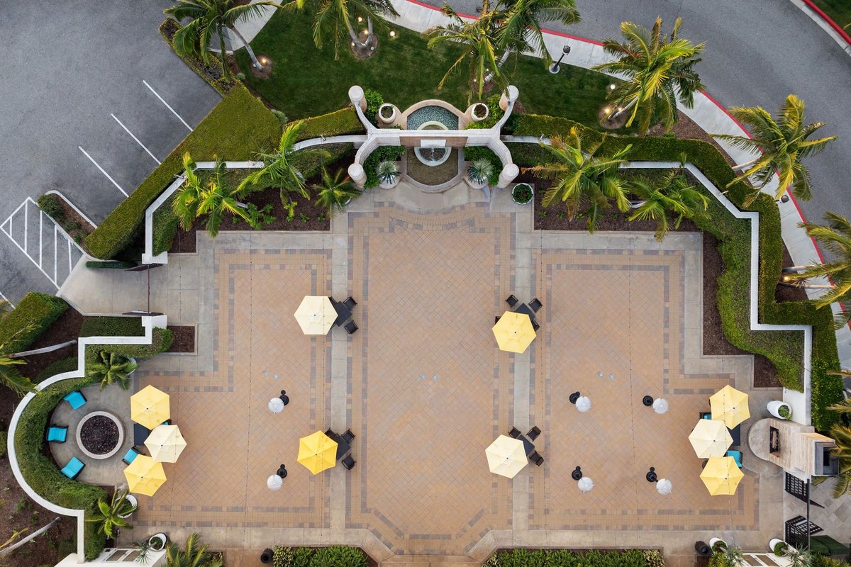 An aerial view of the Bamboo Garden at Renaissance Newport Beach Hotel with umbrellas and a patio