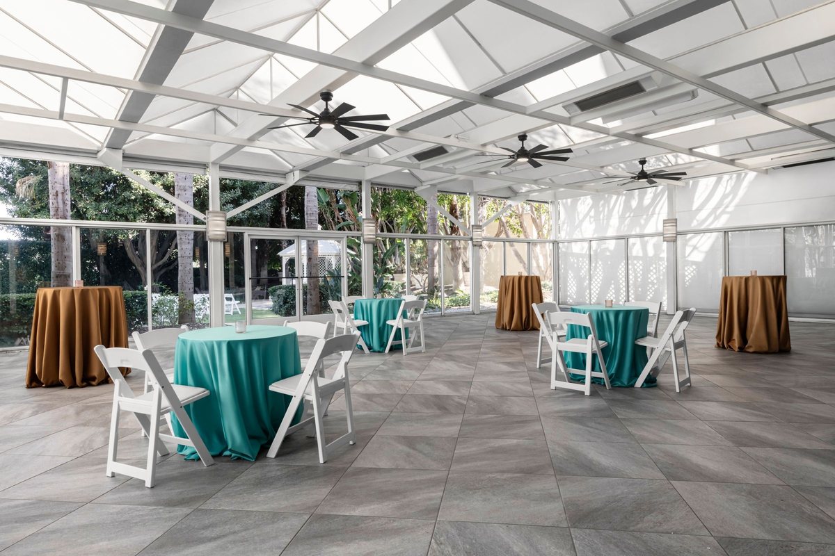 The Orchid Terrace at Renaissance Newport Beach Hotel with a glass roof, ceiling fans and cocktail tables