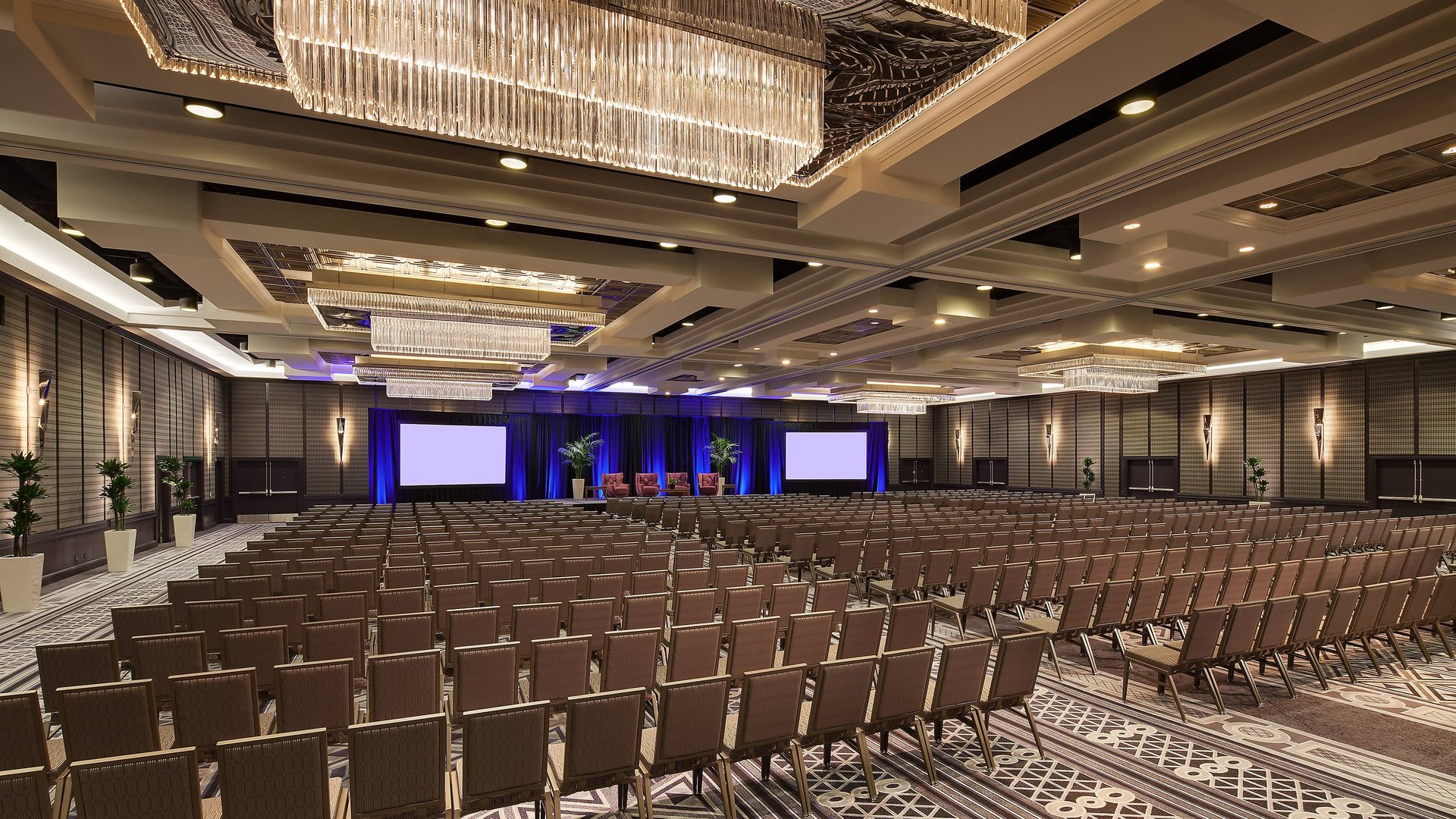 The California Ballroom at Sheraton Grand Los Angeles set theater style facing a stage with three screens