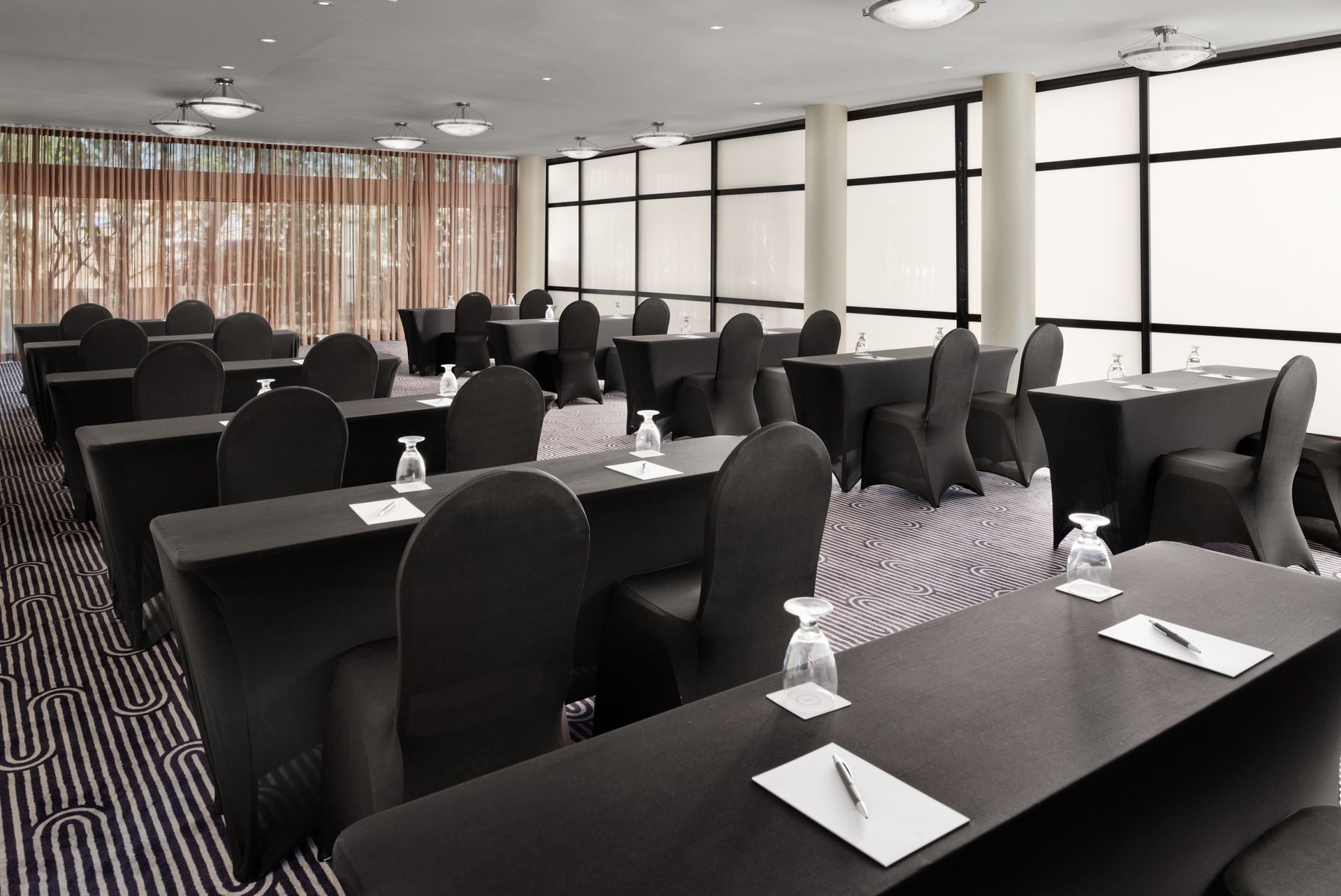 Meeting space at Sheraton Ontario Airport Hotel set classroom style with black tables and chairs