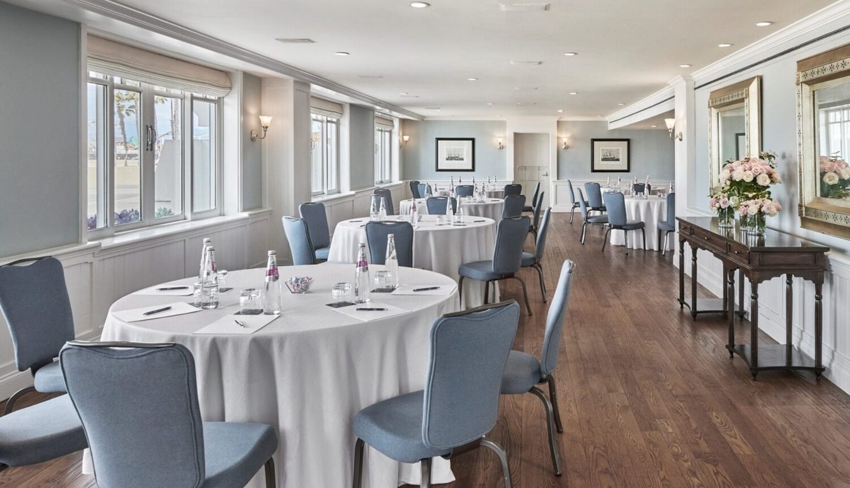 The Beachside room set with round tables and ocean-view windows