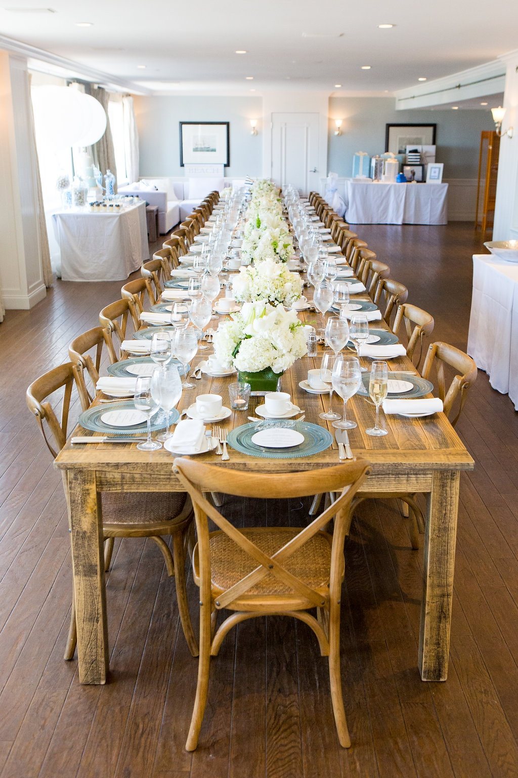 A long dining table set in Beachside with candles and greenery