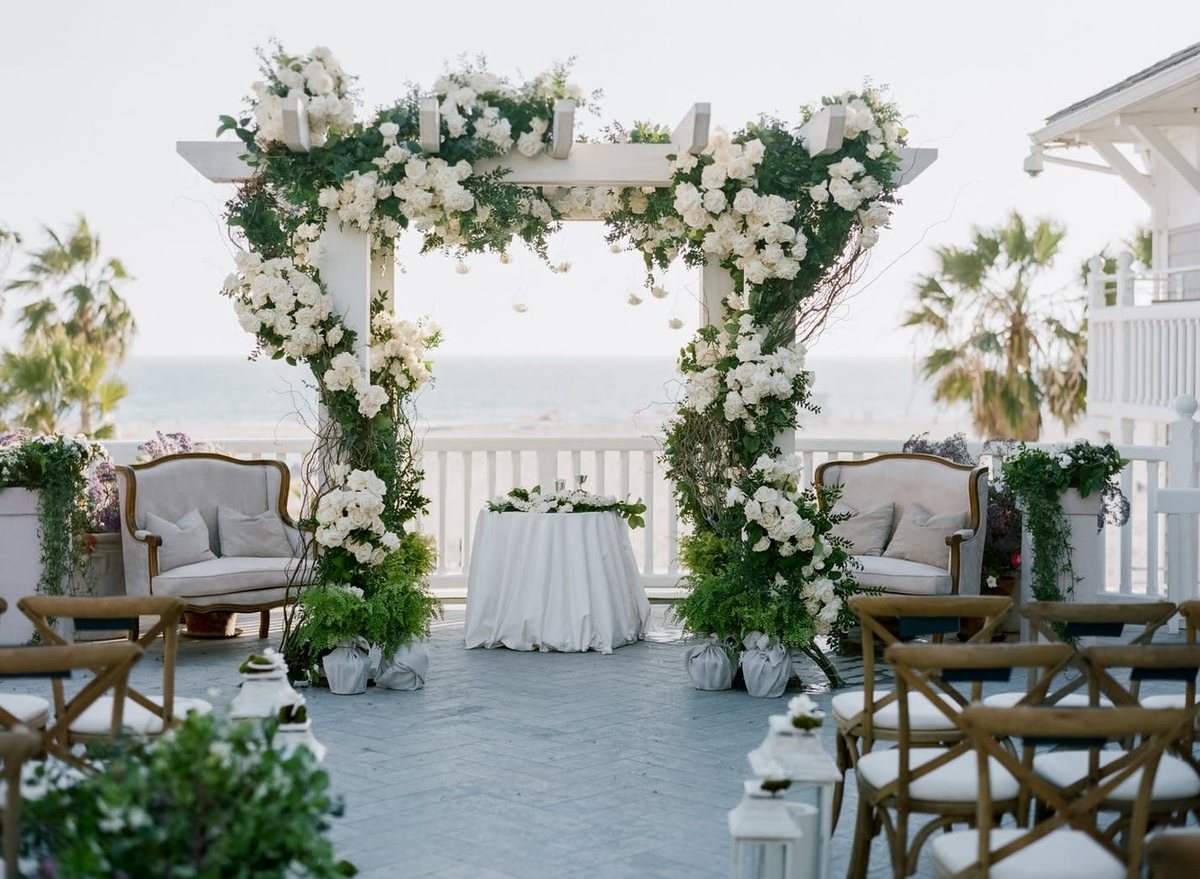 A floral ceremony arch on the Pacific Terrace above the beach