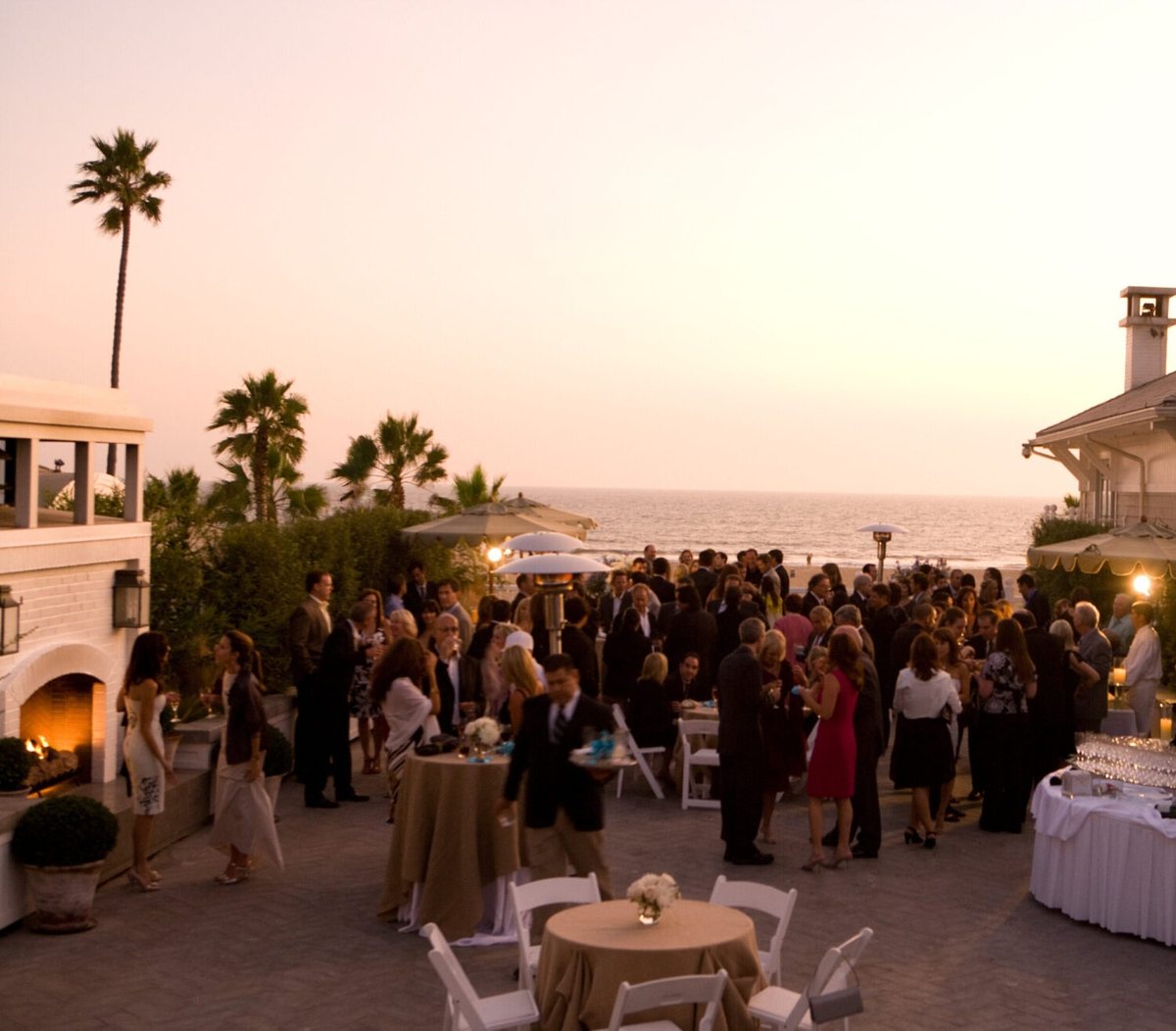 A reception on the Pacific Terrace at sunset with the ocean behind