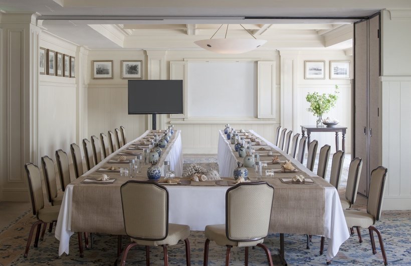 A Promenade section set with a long table and a wall-mounted display