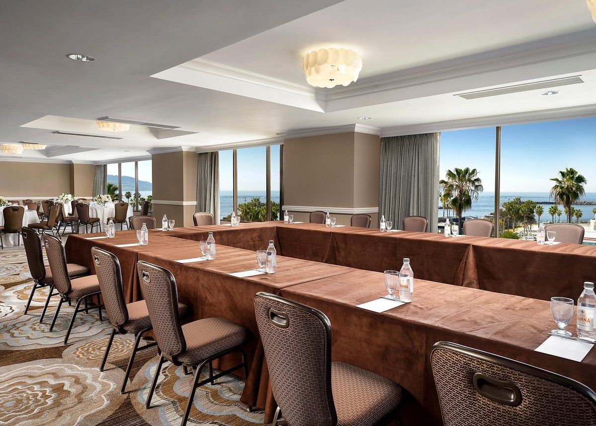 The Promenade room at Sonesta Redondo Beach & Marina set with long tables beside windows