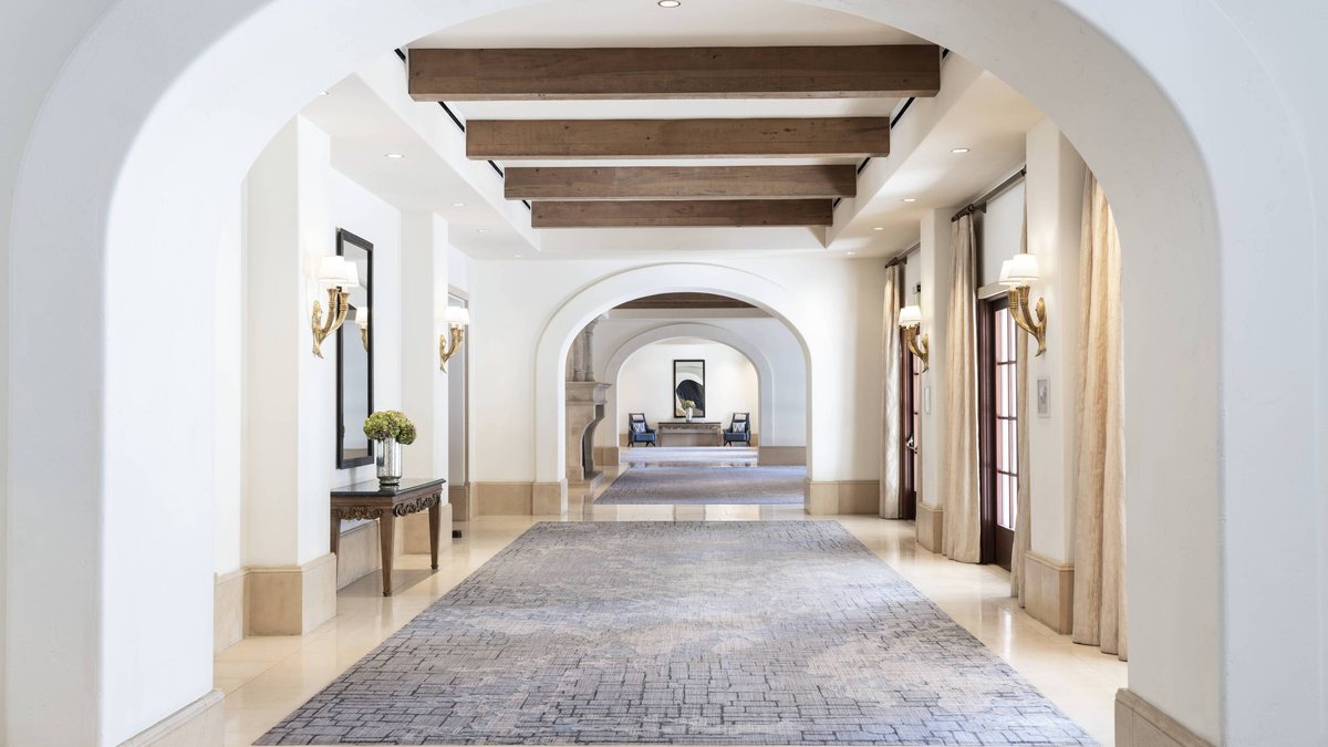 The arched Ballroom Foyer with a beamed ceiling and long runner