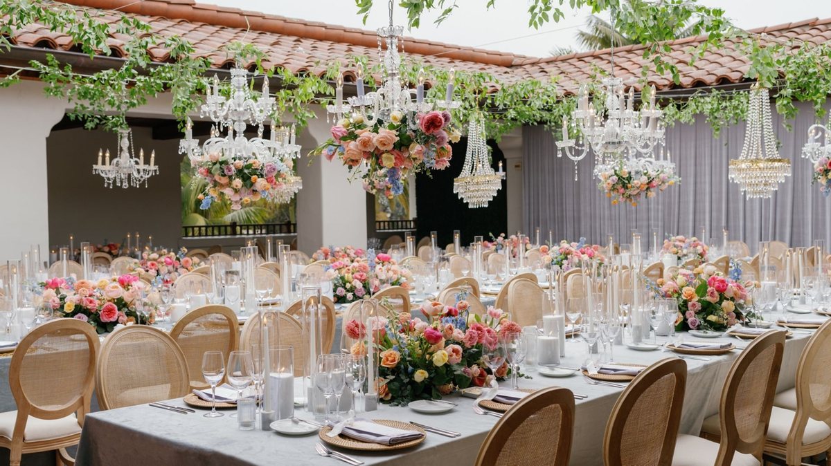 A wedding reception under hanging florals and chandeliers