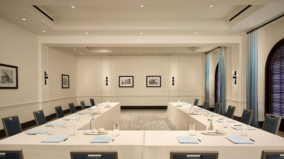 A conference room set U-shape with framed art on the walls