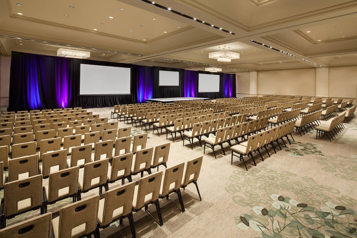 The California Ballroom set theater style with two screens and purple uplighting