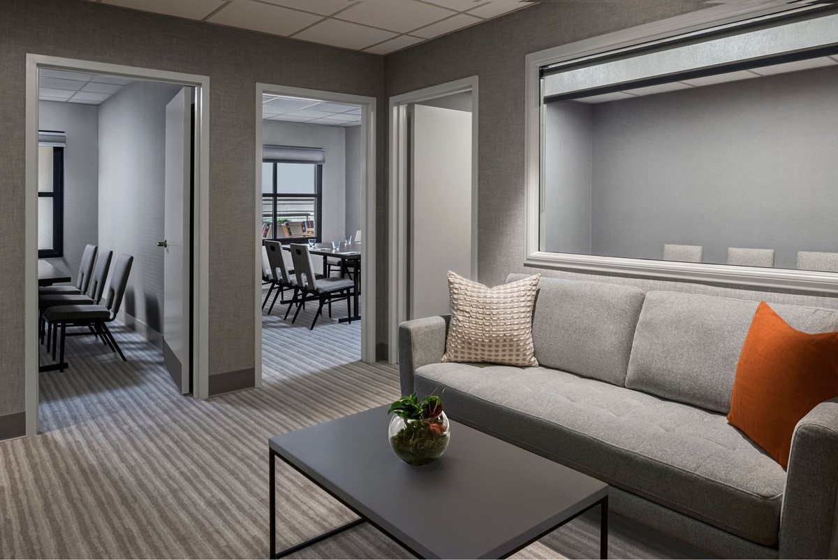 A Cardiff room with a sofa, a coffee table and an adjoining meeting room