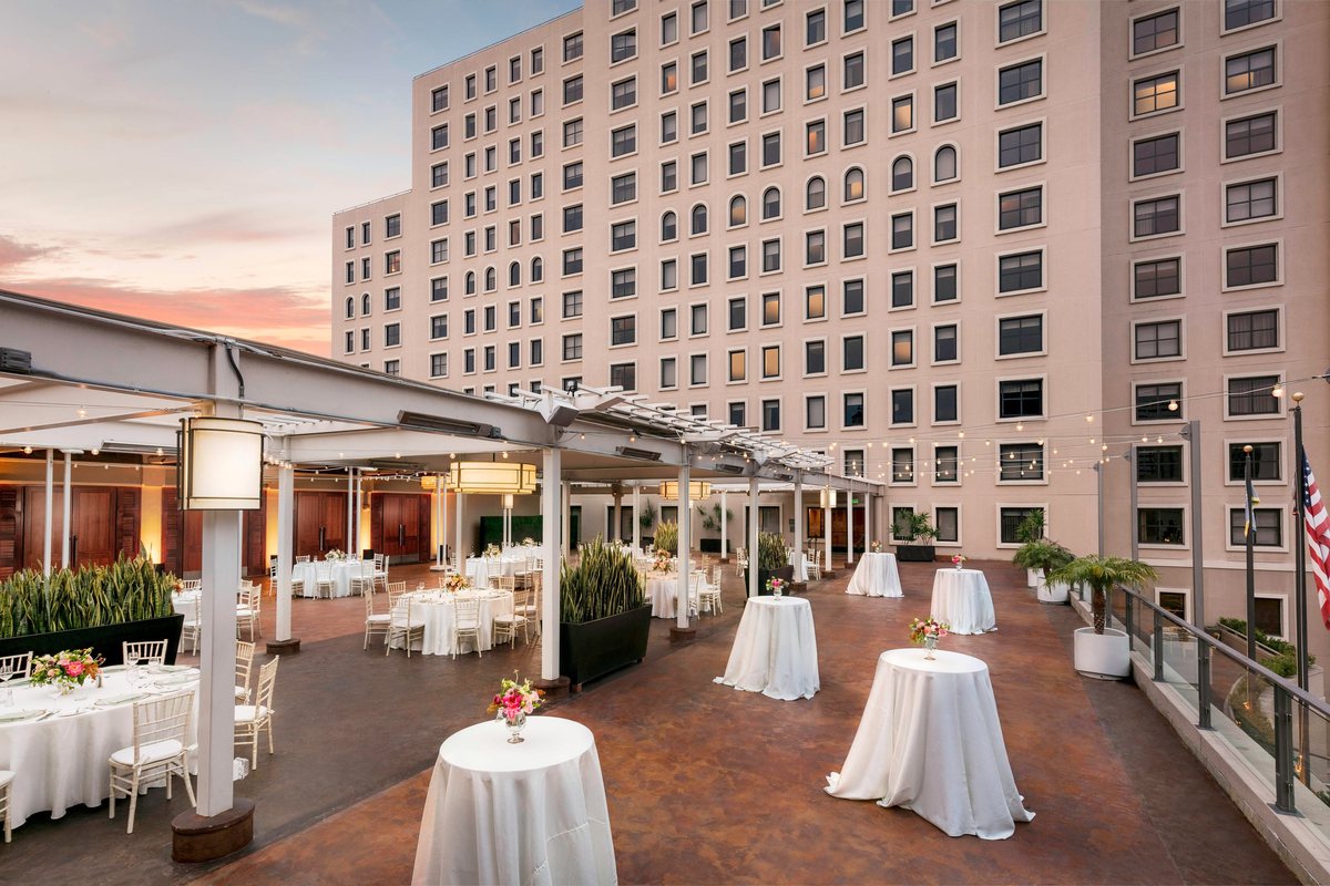 Cocktail tables on the Garden Terrace at dusk with downtown towers behind